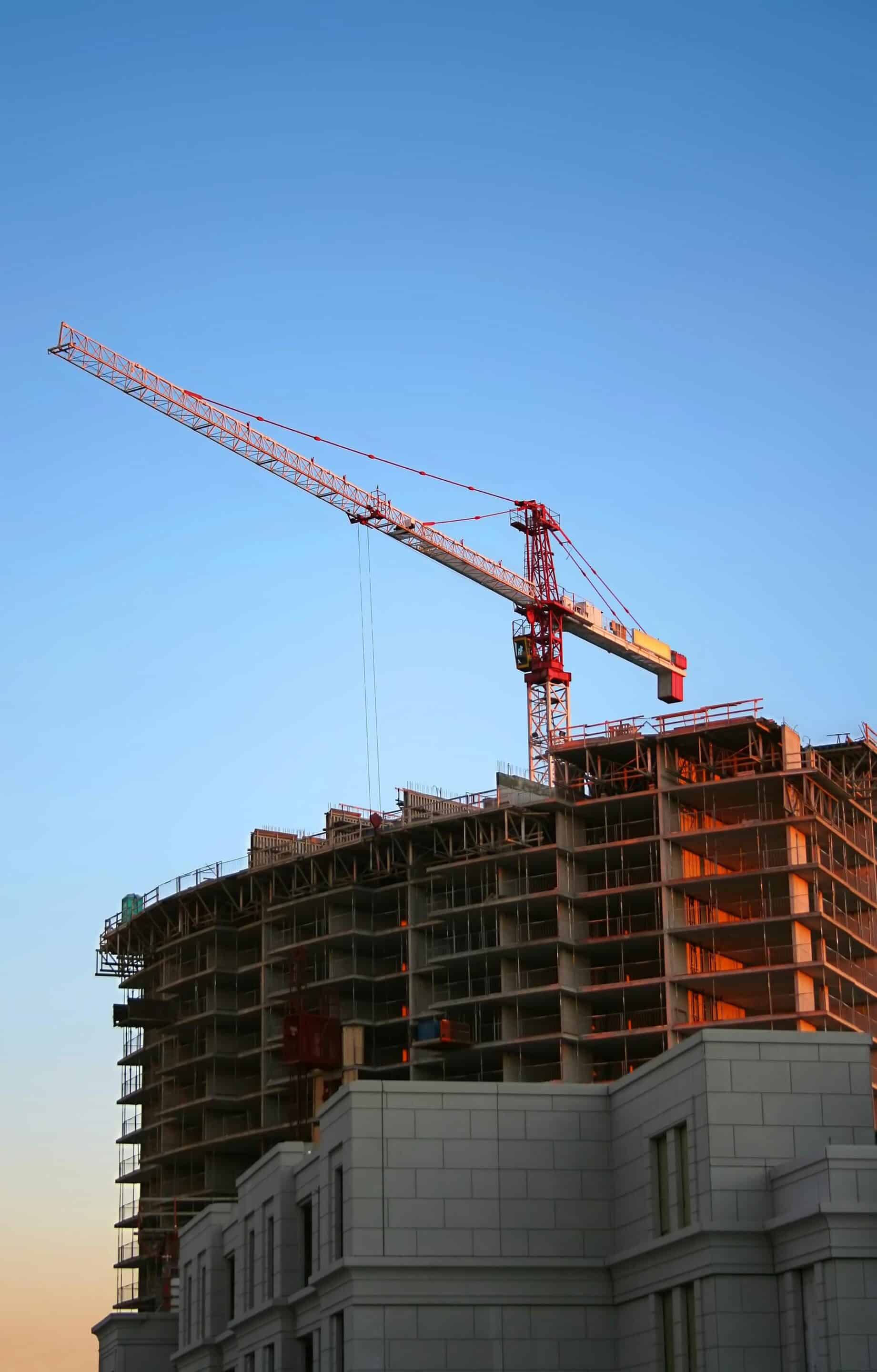 Construction crane building a high-rise structure at sunset, representing strong foundational online directory listings and citation authority that support local SEO growth for businesses in Grand Rapids, Detroit, and Marquette.
