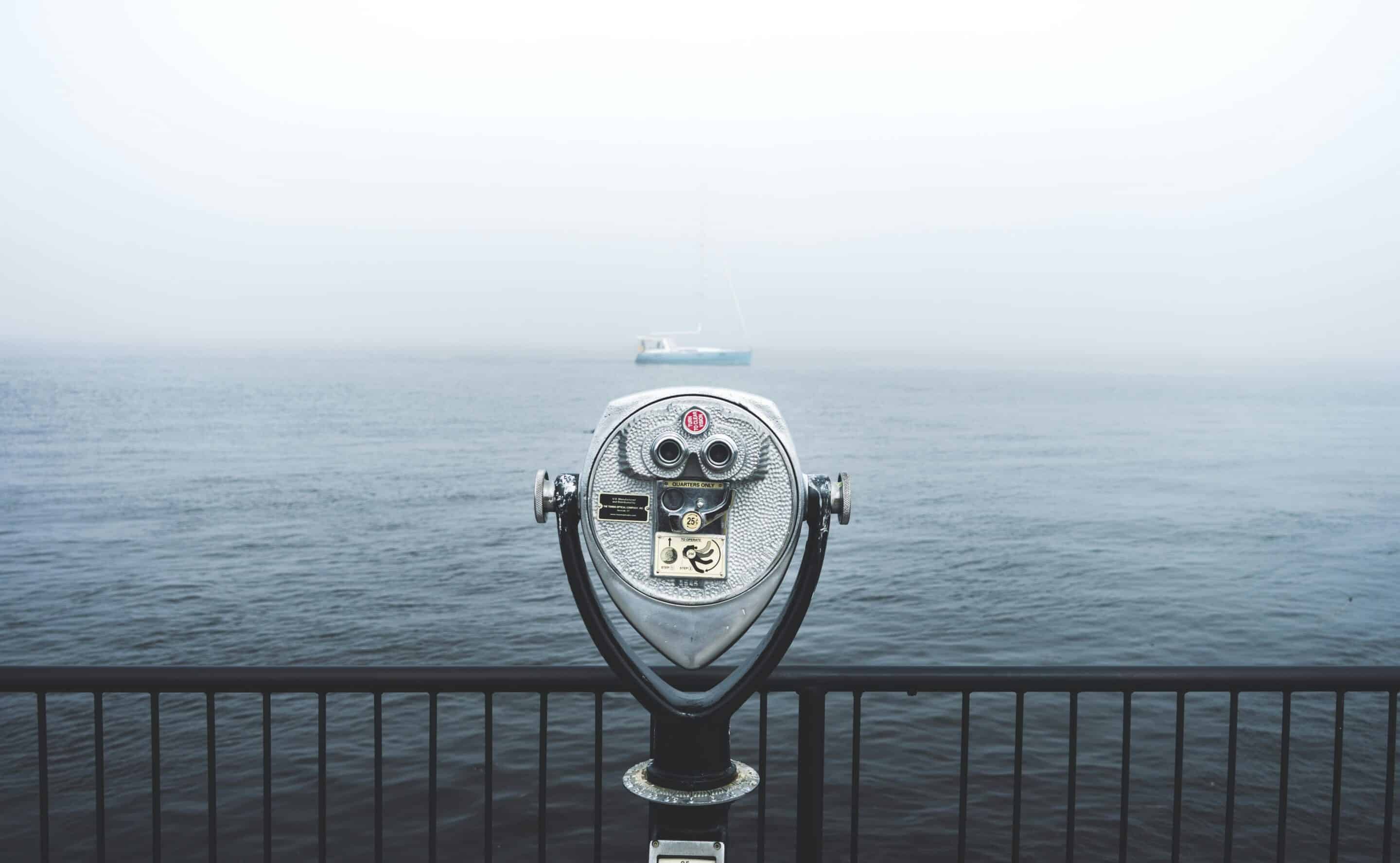 Coin-operated waterfront binocular viewer overlooking Lake Michigan, symbolizing clear, accurate business information and improved local search visibility for companies in Grand Rapids, Detroit, and Marquette through NAP cleanup and citation accuracy.