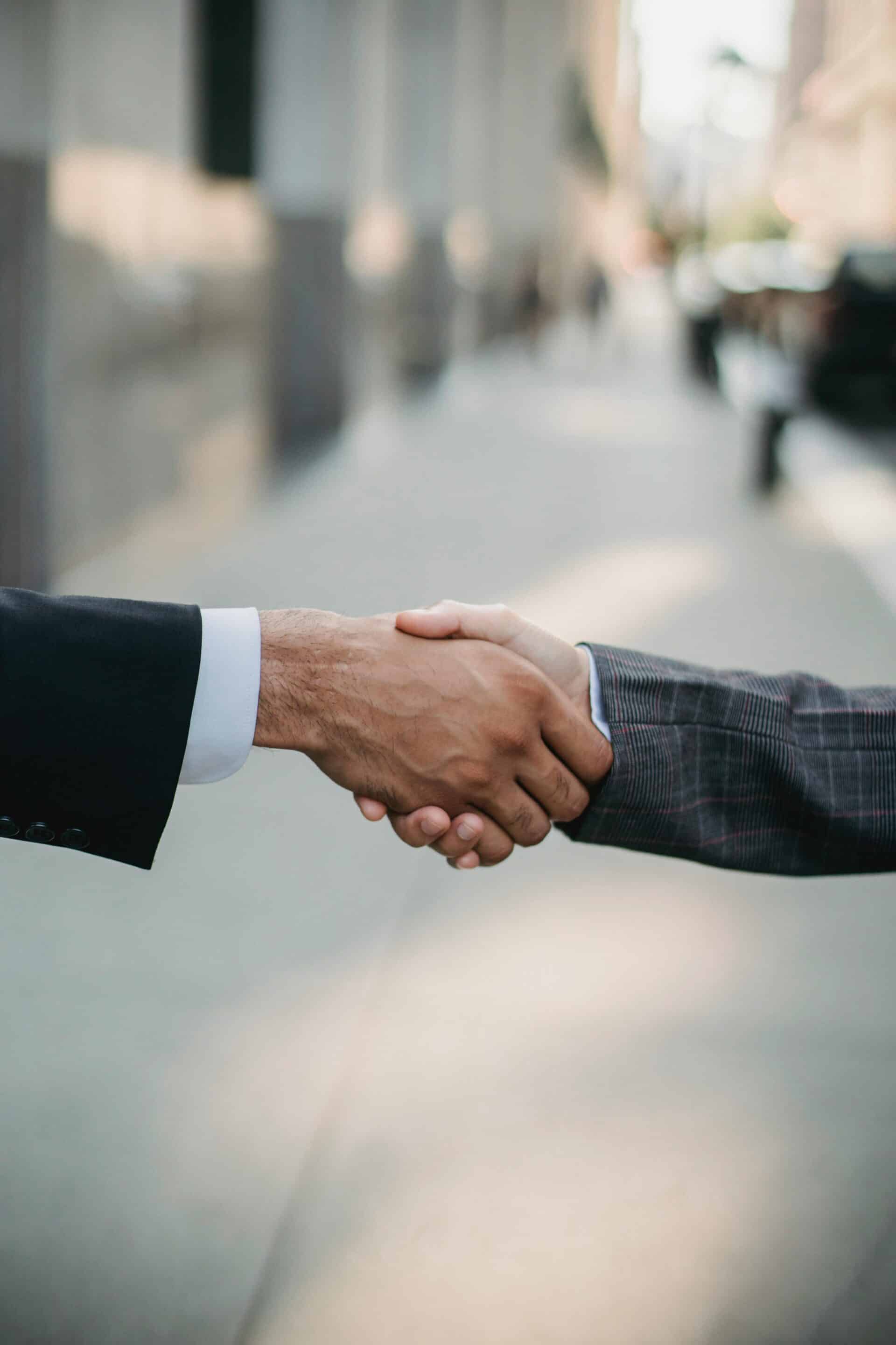 Business handshake symbolizing partnership and trust built by Cotes Code to strengthen AI visibility for brands in Grand Rapids, Ada, and surrounding West Michigan