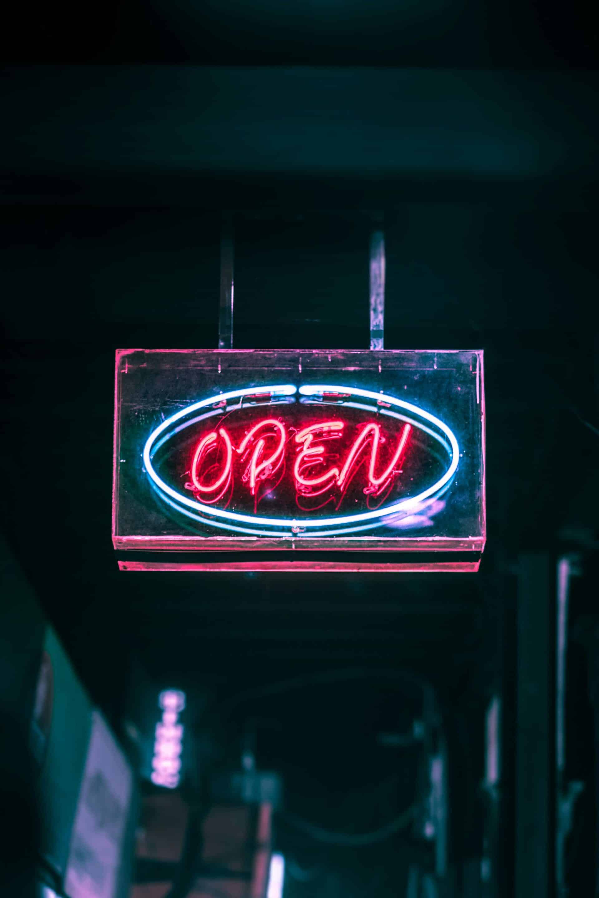 Neon “Open” sign glowing in a dark storefront, representing active Google Business Profile management that helps local businesses in Grand Rapids, Detroit, and Marquette stay visible, attract customers, and generate leads.